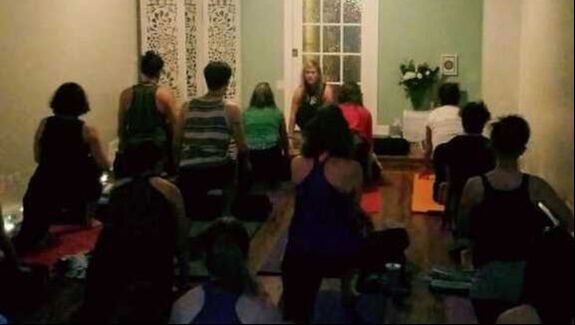 a group practicing yoga in the evening at our studio in Lakeview