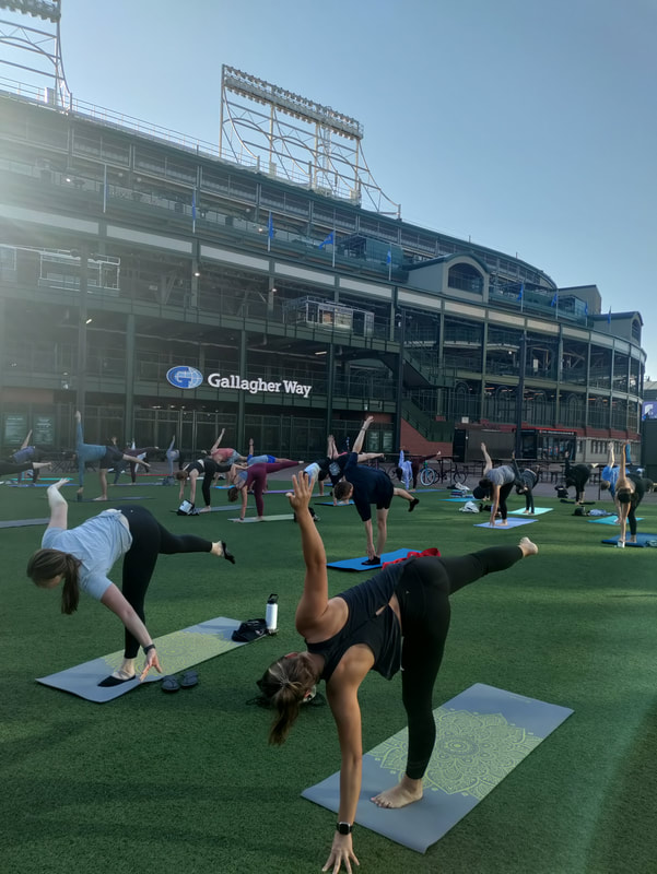 People doing Half Moon Pose in front of Wrigley Field