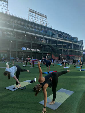 People doing half moon pose during a yoga class outside Wrigley Field