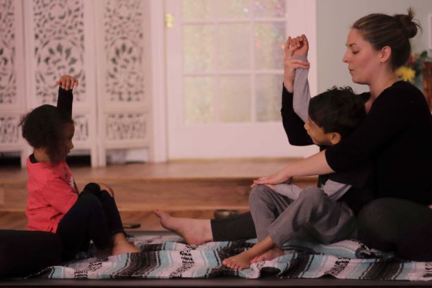 children practicing yoga with a children's yoga teacher